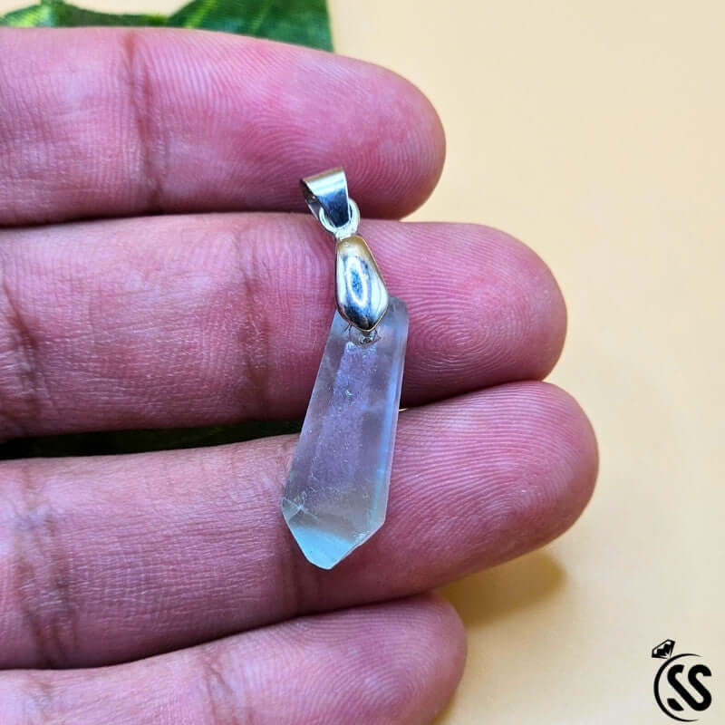Handcrafted Fluorite real stone pendant featuring calming hues for clarity and protection, displayed in a hand.