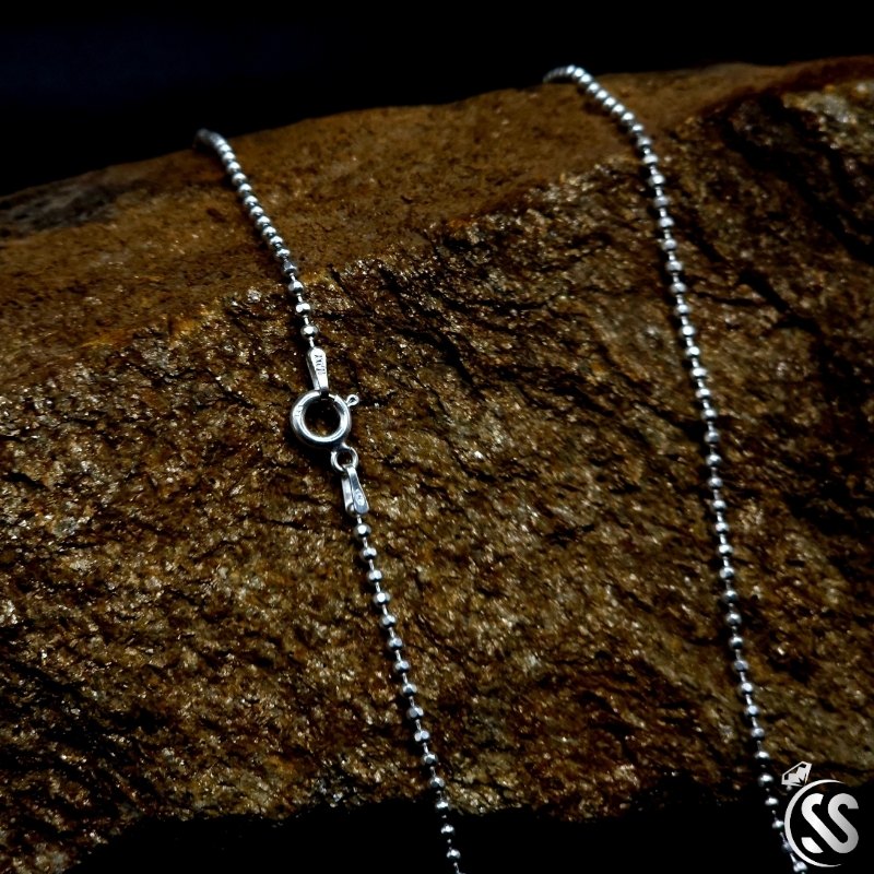 Italian Silver Sterling 925 ladies ball chain close-up, showcasing clasp and bead details against a textured stone background.