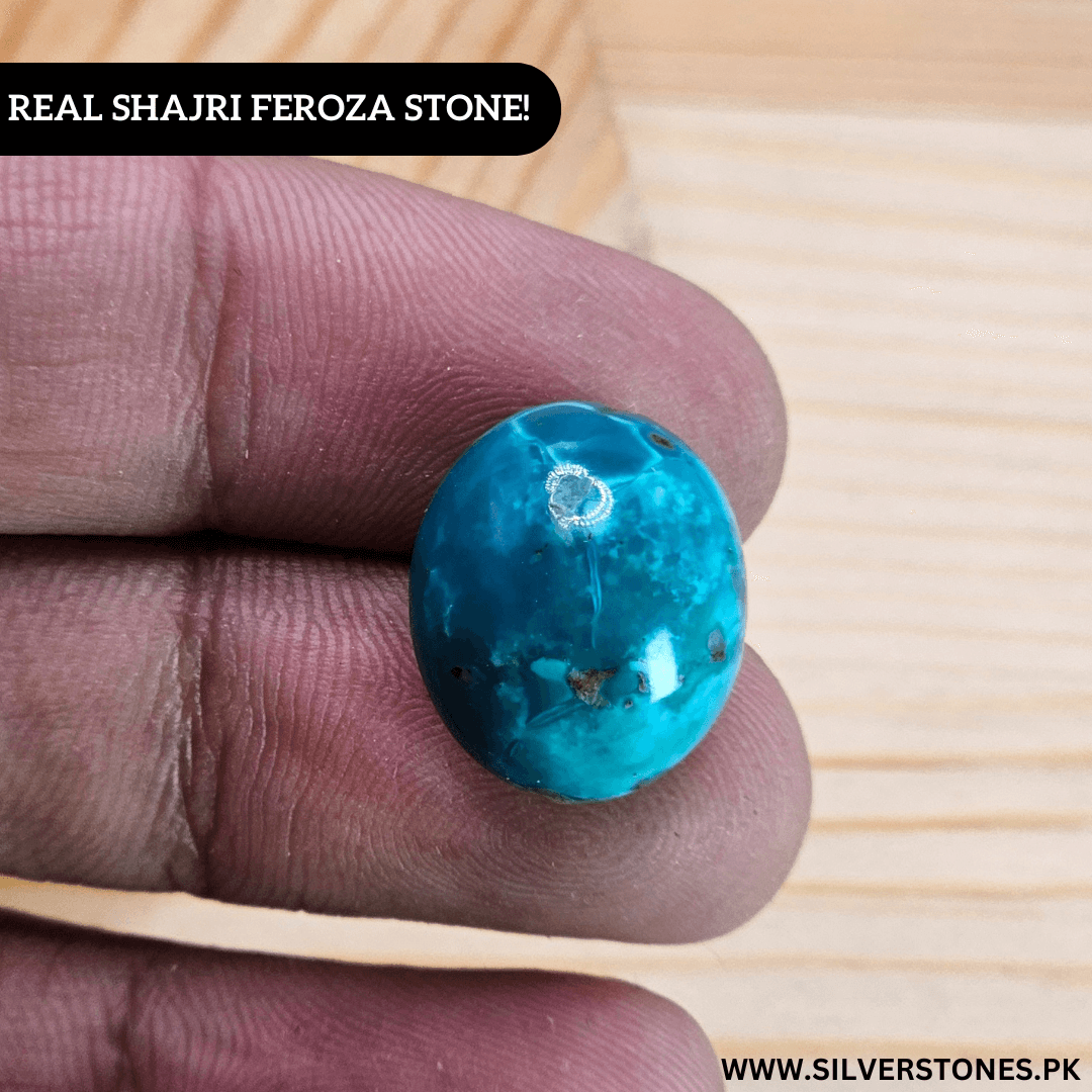 Authentic Shajri Irani Feroza stone in hand, showcasing its vibrant turquoise color and oval shape.