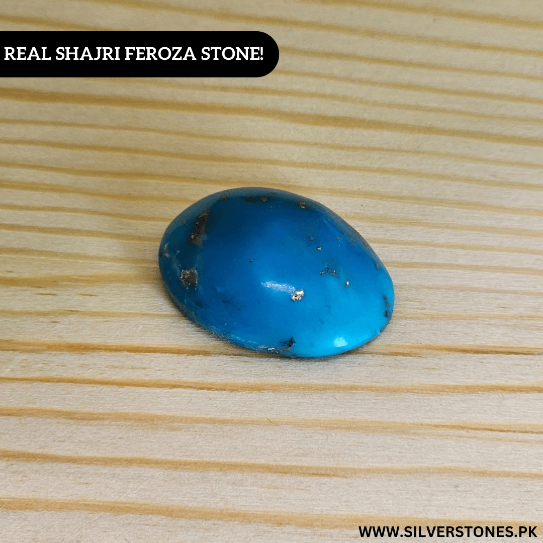 Real Shajri Irani Feroza stone, oval shaped turquoise piece on wooden surface.