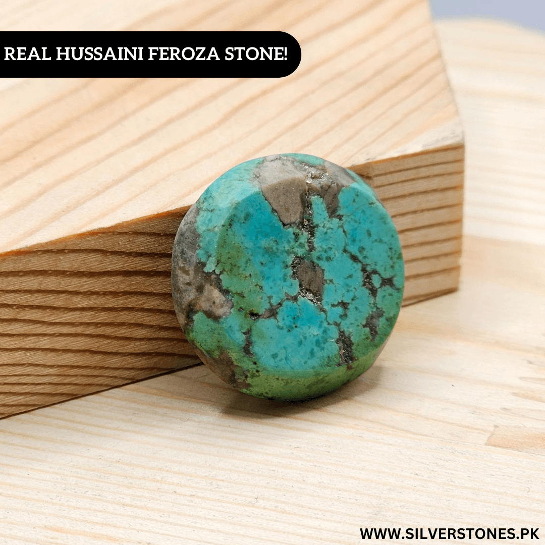 Round real Shajri Hussaini Feroza stone showcasing natural turquoise veins on a wooden background.
