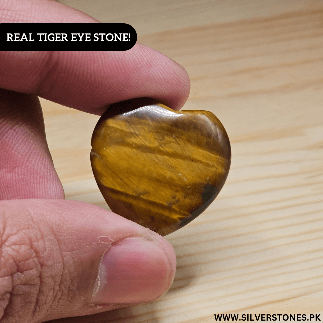 Heart-shaped Real Tiger Eye Stone held in hand, showcasing its golden and brown hues.