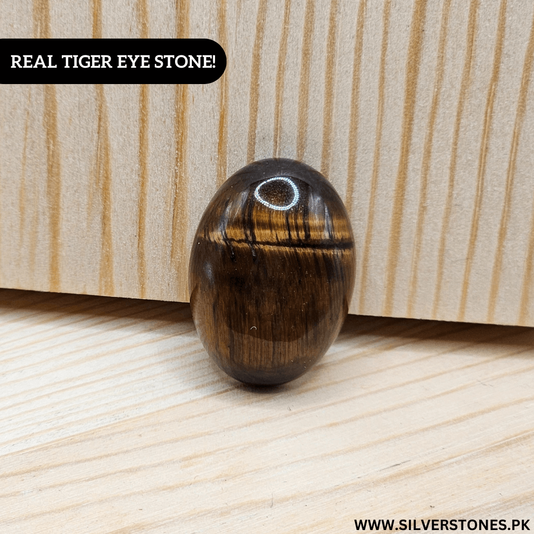 Real Tiger Eye Stone on a wooden surface showcasing its golden and brown hues, symbolizing strength and protection.