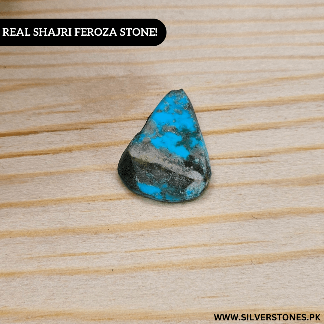Real Shajri Irani Feroza stone, pear-shaped turquoise gem on wooden surface, showcasing its antique beauty.