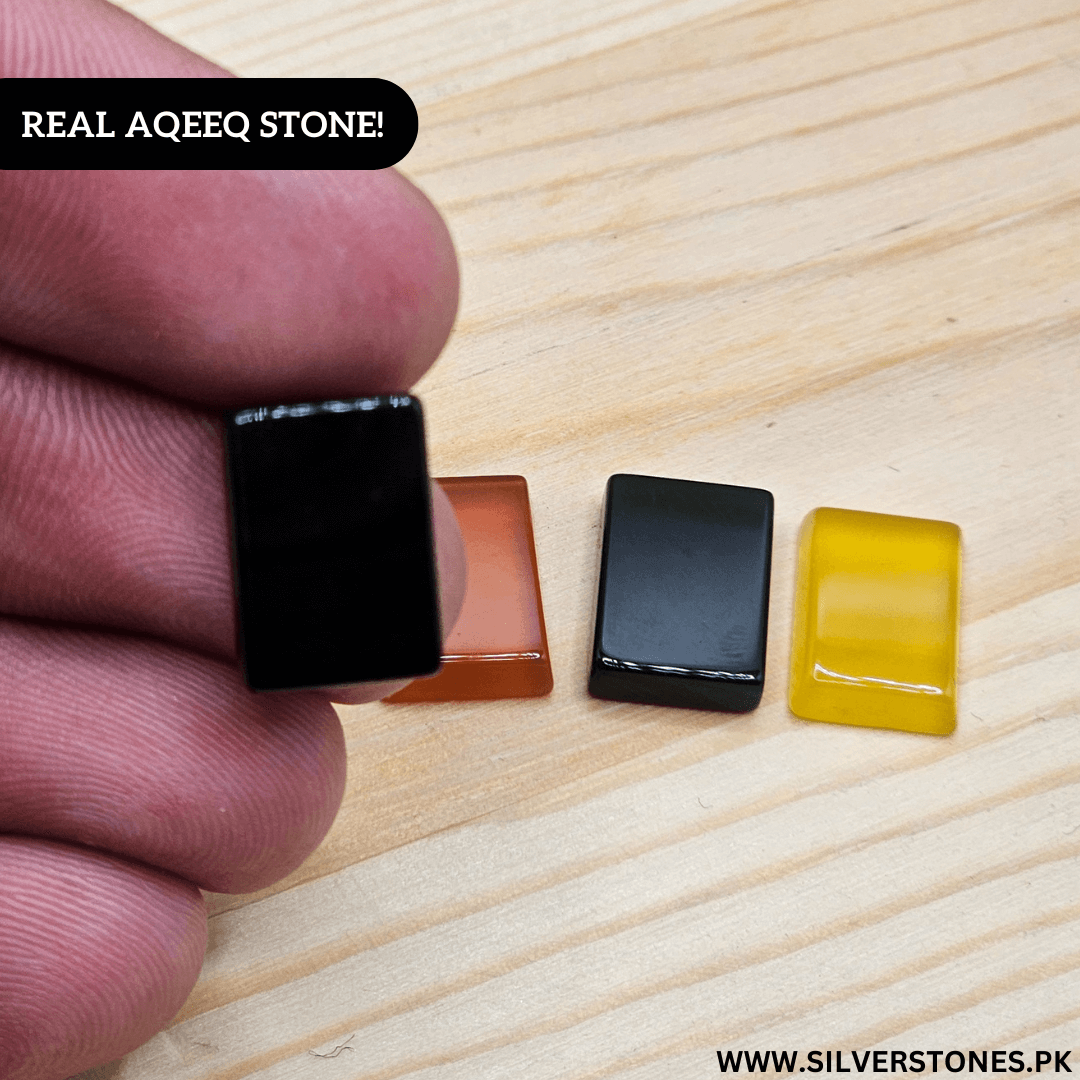 Hand holding a real Yamni Aqeeq stone, showcasing its natural beauty alongside other colored stones.