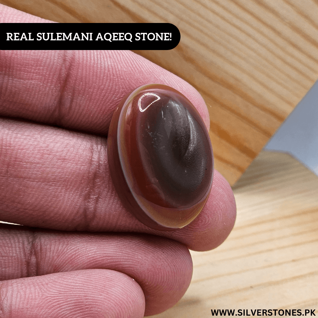 Hand holding a Real Sulemani Aqeeq Stone showcasing its unique colors and smooth surface, symbolizing strength and protection.