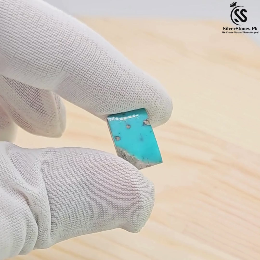 Hand holding a rectangular Real Shajri Irani Feroza stone, showcasing its vibrant turquoise color and unique natural patterns.