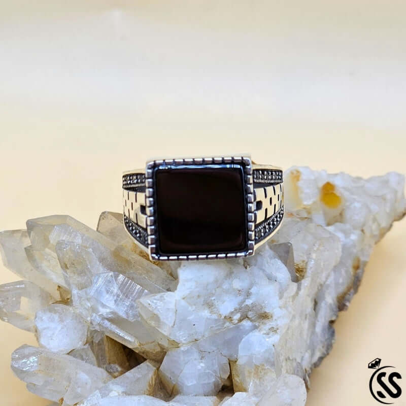 Vintage Turkish 925 sterling silver gents ring with square black stone on a crystal display.