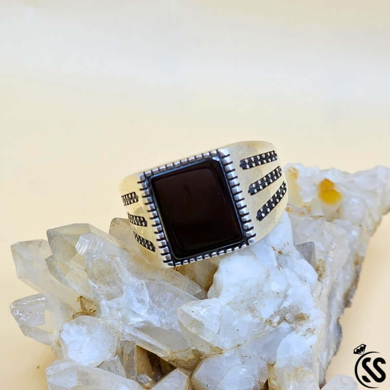 Vintage Turkish 925 sterling silver gents ring with square black stone on quartz crystal backdrop.