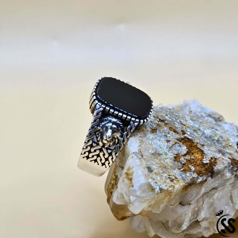 Vintage Turkish 925 sterling silver gents ring with black stone, displayed on a crystal base.