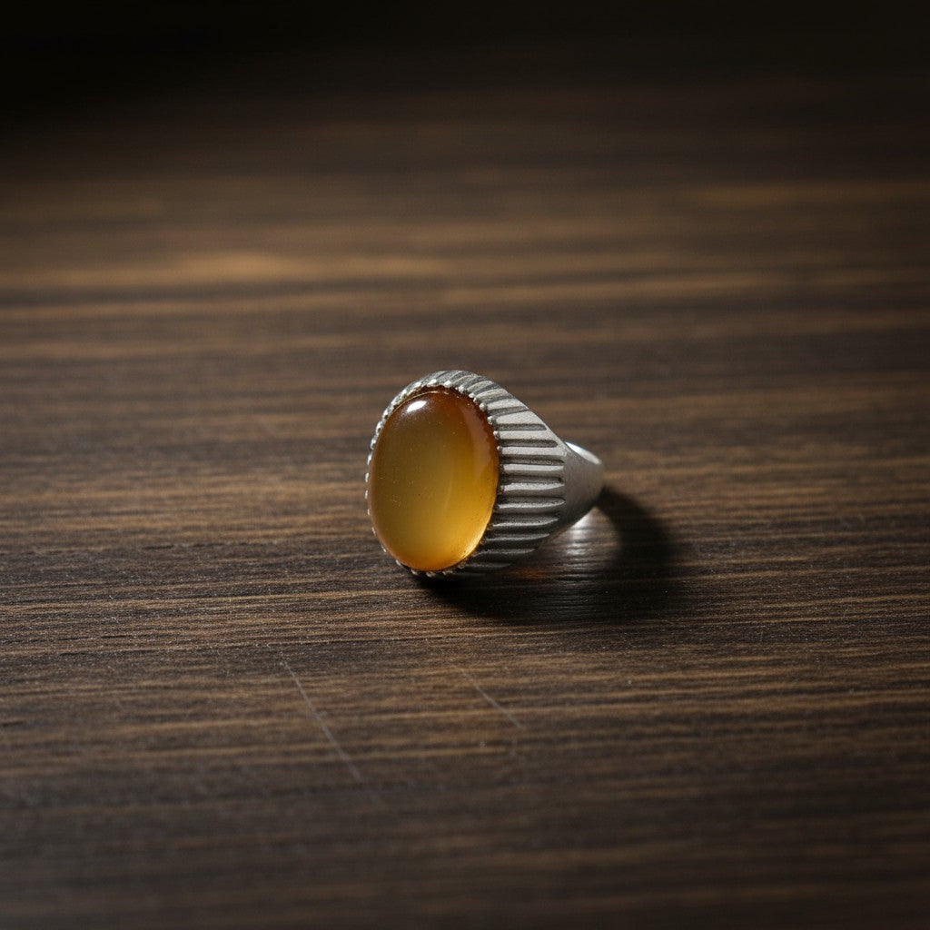 SilverStones.Pk men's ring with oval carnelian gemstone and ribbed silver-tone band. Warm amber to orange hues.