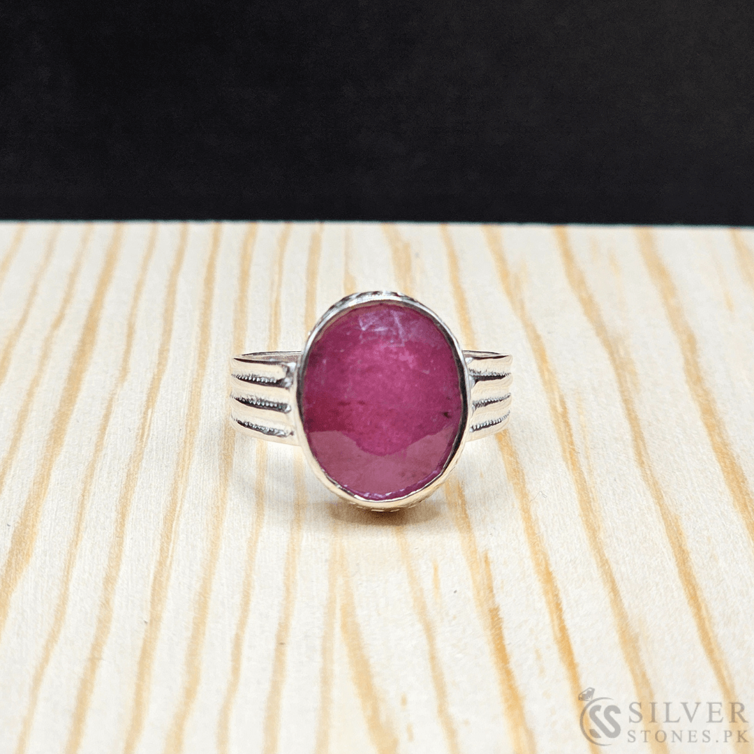 Handmade real ruby silver ring with a 7-carat African ruby gemstone on a wooden surface.