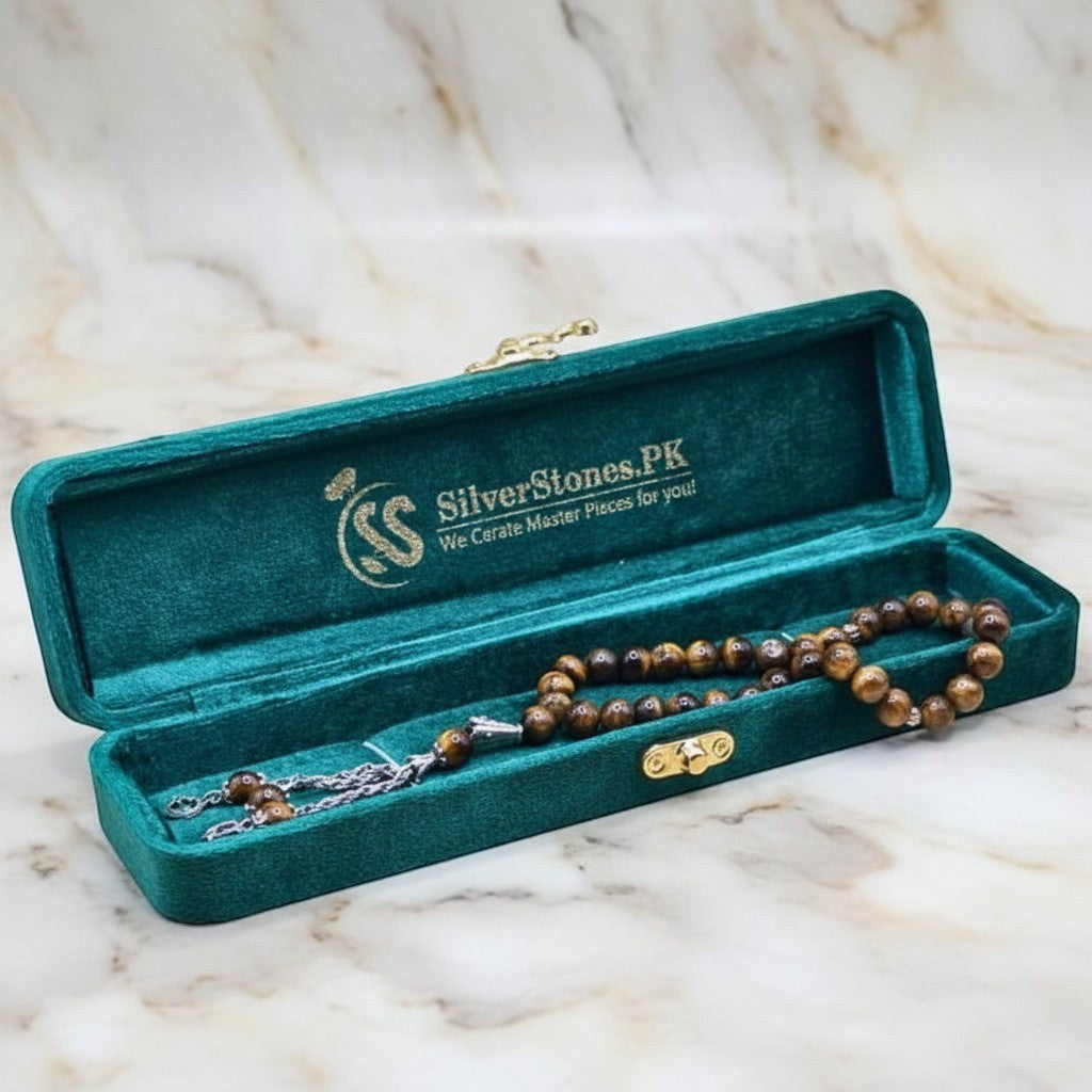 SilverStones.Pk Real Tiger Stone Tasbeeh with golden-brown striped beads and silver tassel in a teal velvet box.