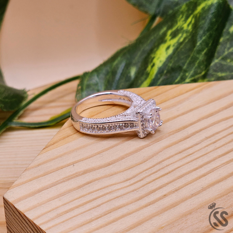 925 Italian silver ladies ring with zircons on a wooden surface, showcasing its sparkling design.