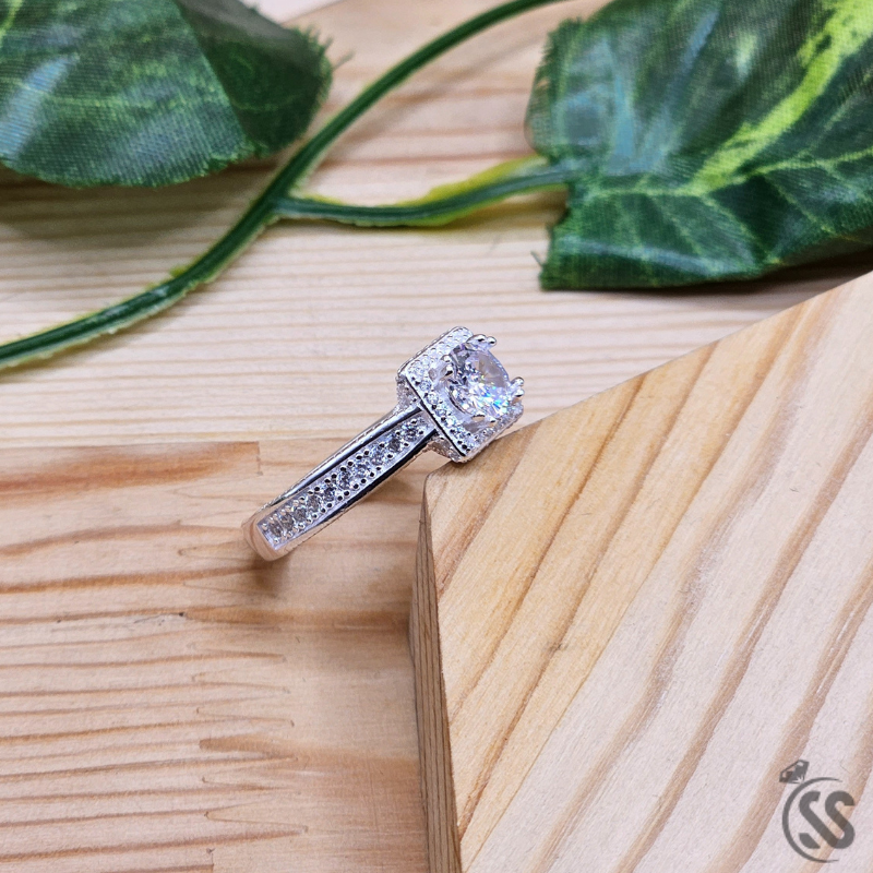 925 Italian silver ladies ring with zircons beautifully displayed on a wooden surface surrounded by greenery.