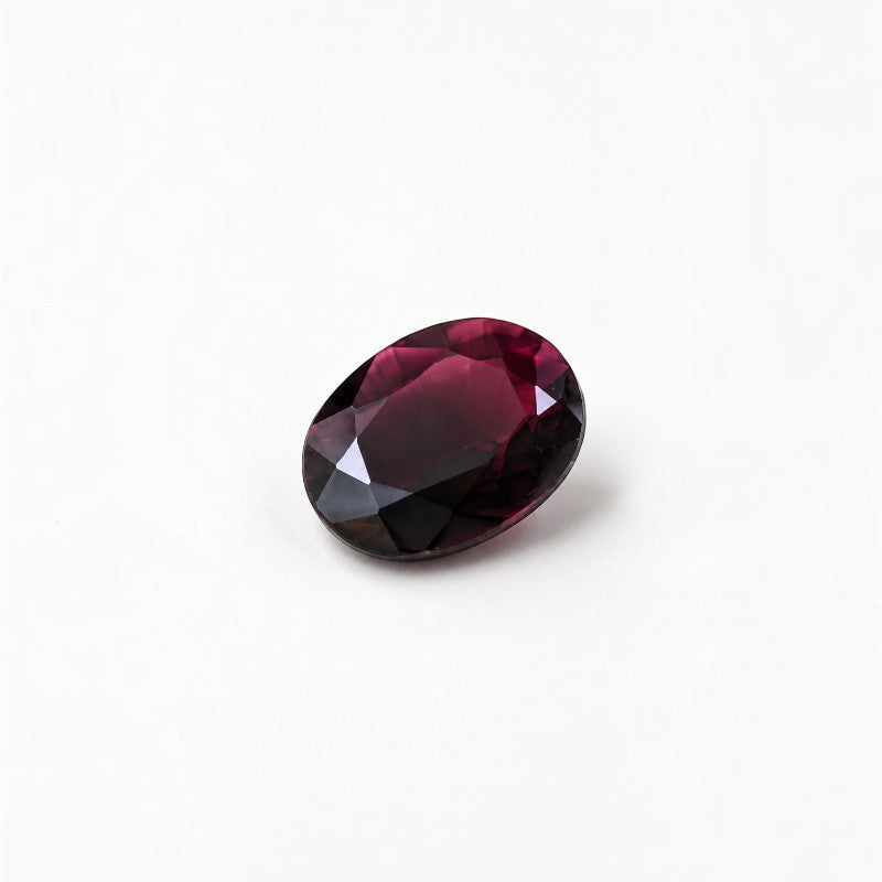 SilverStones.Pk oval cut faceted deep purple gemstone with high clarity and brilliant light reflection.