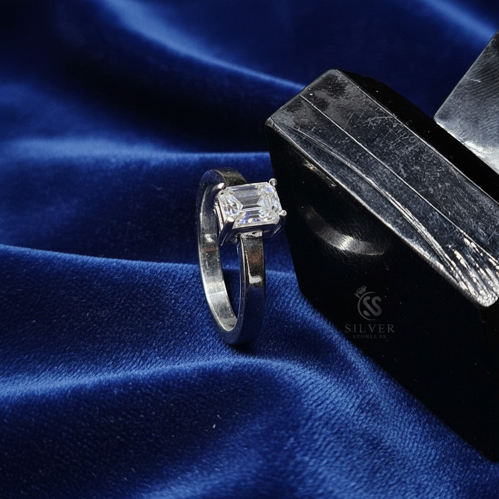 SilverStones.Pk ladies' 1 carat emerald-cut moissanite diamond ring in silver, presented on a black display stand.