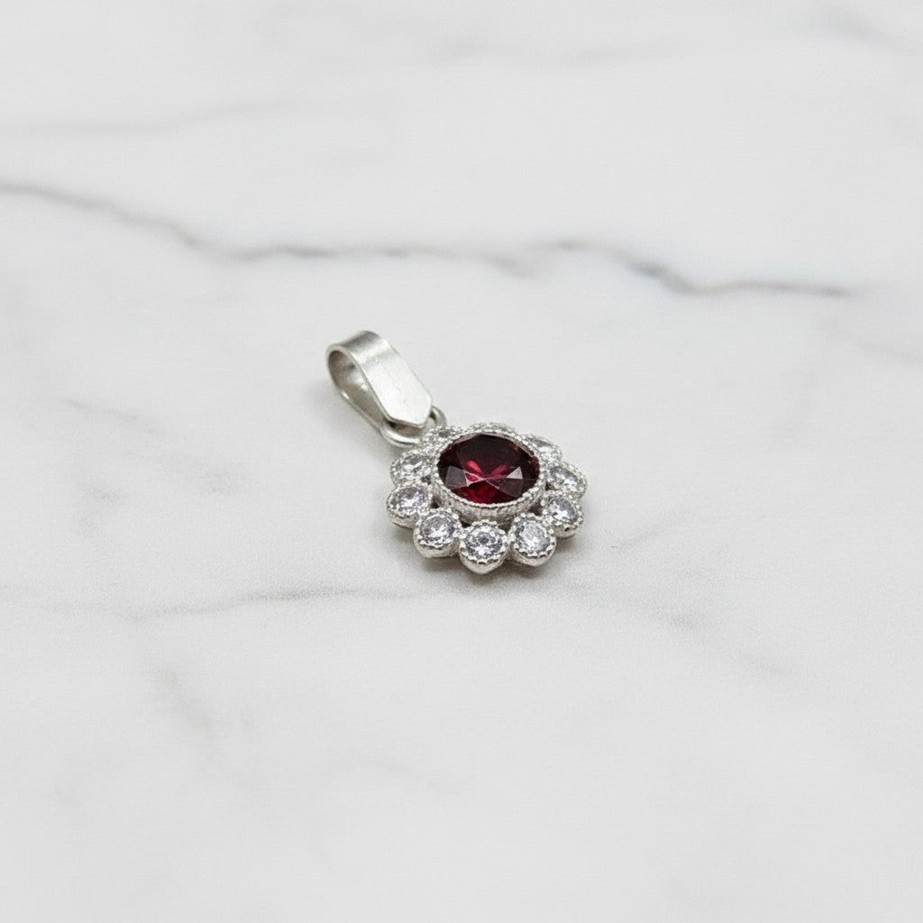 SilverStones.Pk 925 sterling silver pendant with a central deep red zircon stone surrounded by clear zircon stones in a floral design.