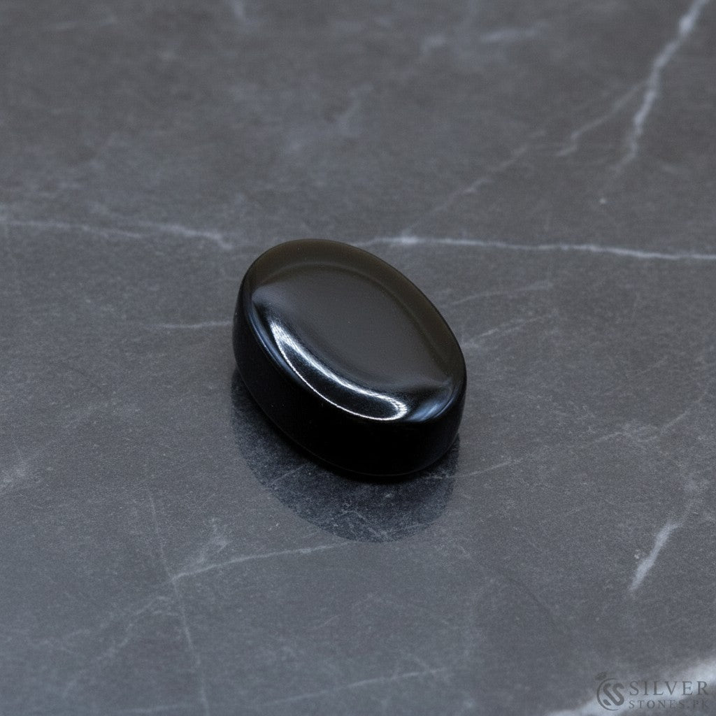 SilverStones.Pk oval black irani aqeeq stone, polished with a smooth finish, ideal for jewelry.