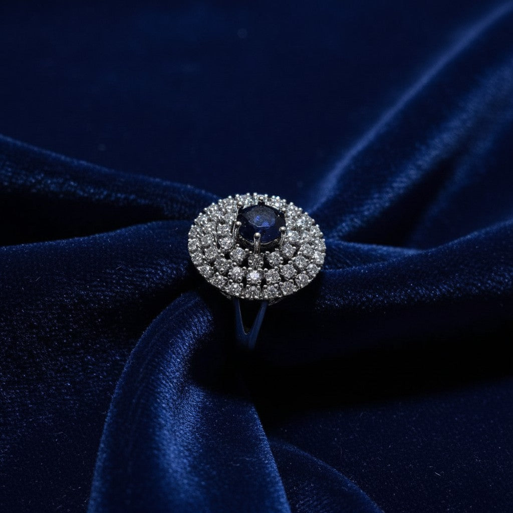 SilverStones.Pk A+ quality imitation ring with a central dark blue zircon surrounded by small clear zircon stones. Color silver.