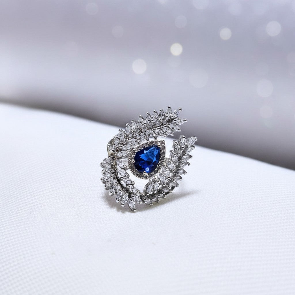 SilverStones.Pk A+ quality imitation ring with a pear-cut blue zircon center stone surrounded by clear zircon accents.