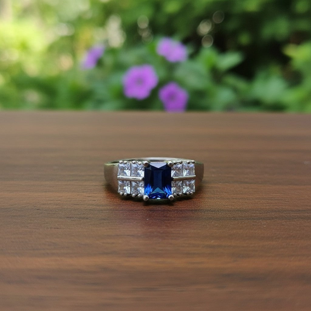SilverStones.Pk elegant ladies ring with a central blue zircon and clear side stones, crafted from color silver.