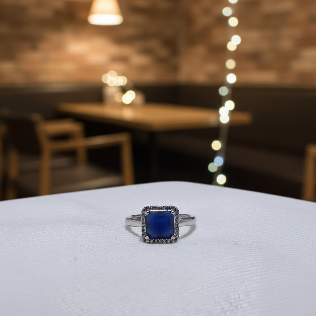 SilverStones.Pk imitation ring with a square blue zircon stone surrounded by small clear stones. Color silver.