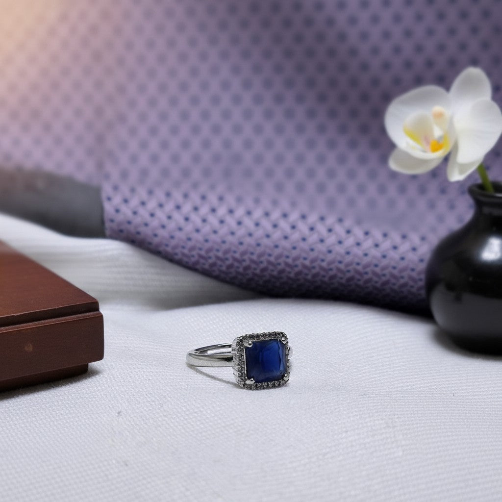 SilverStones.Pk A+ quality imitation ring with a square deep blue zircon stone surrounded by small clear zircon stones.