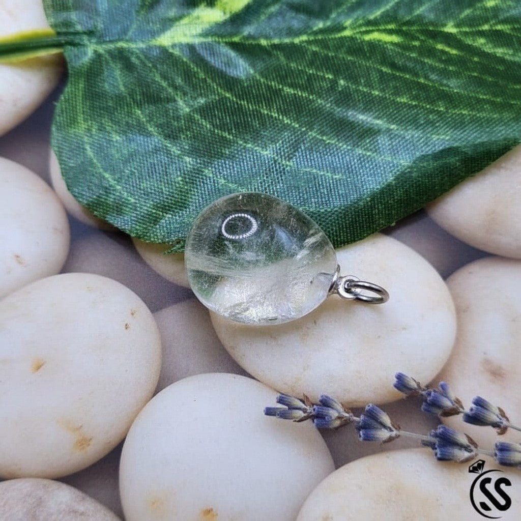 SilverStones.Pk clear quartz pendant, a transparent, naturally shaped stone with a nickel-free metal hook.