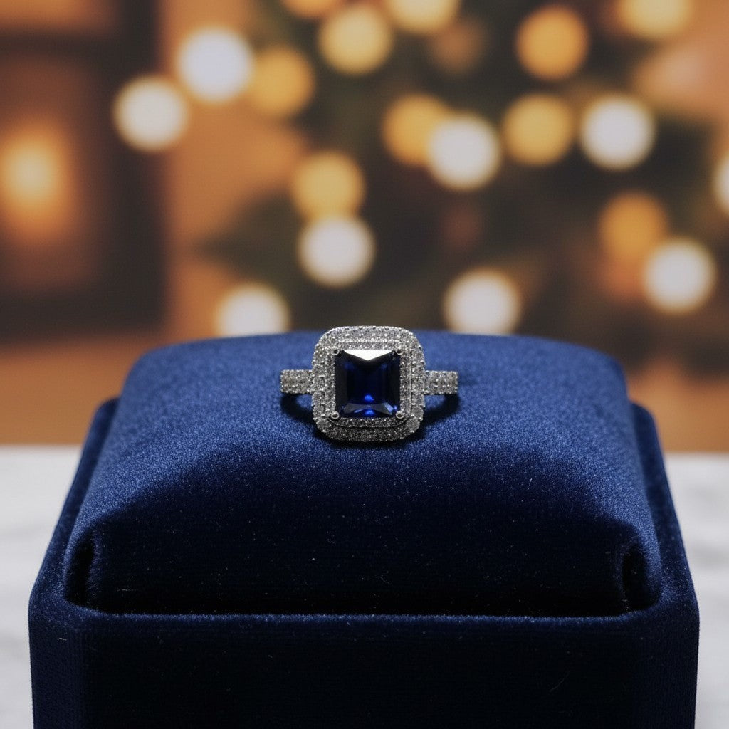 SilverStones.Pk elegant ladies ring with a central dark blue zircon stone, surrounded by smaller clear zircon stones. Silver band.