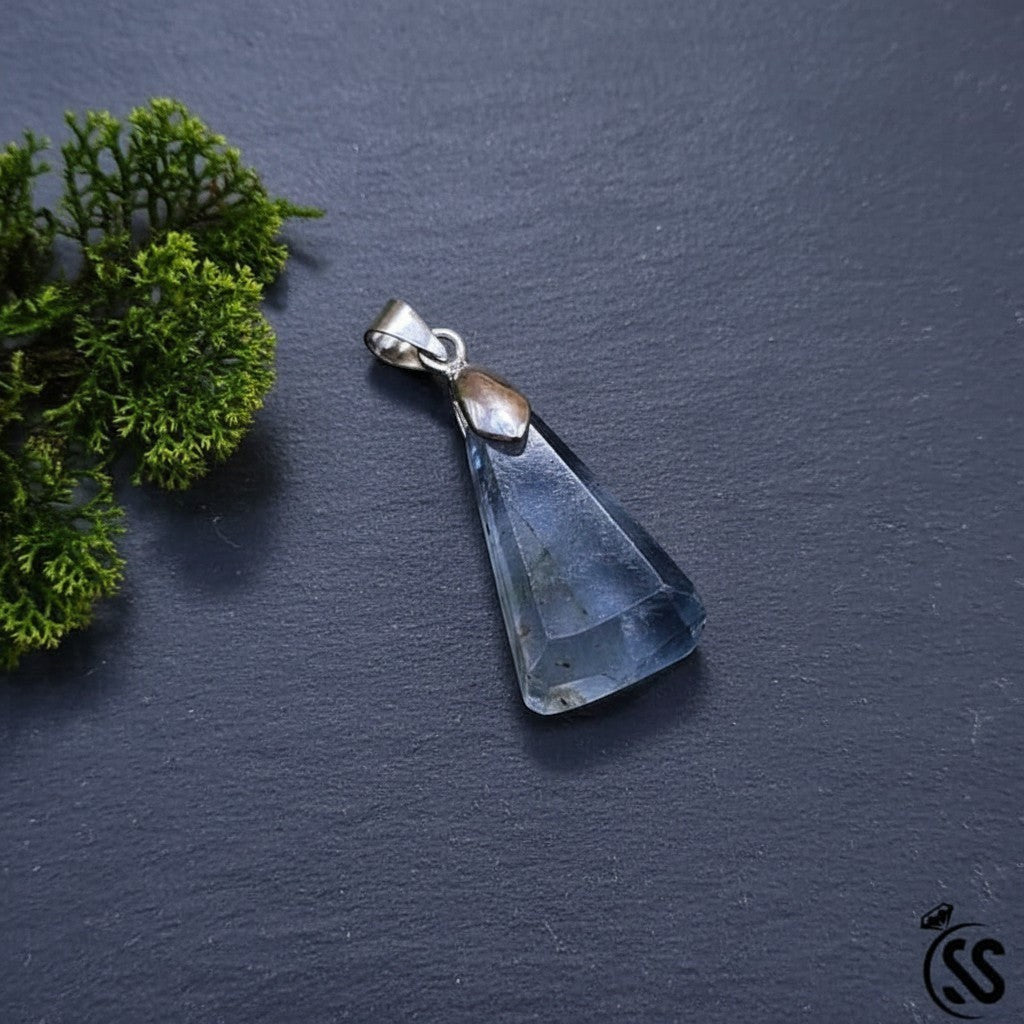 SilverStones.Pk triangular fluorite pendant with a silver-toned metal hook. Features natural purple and green hues.