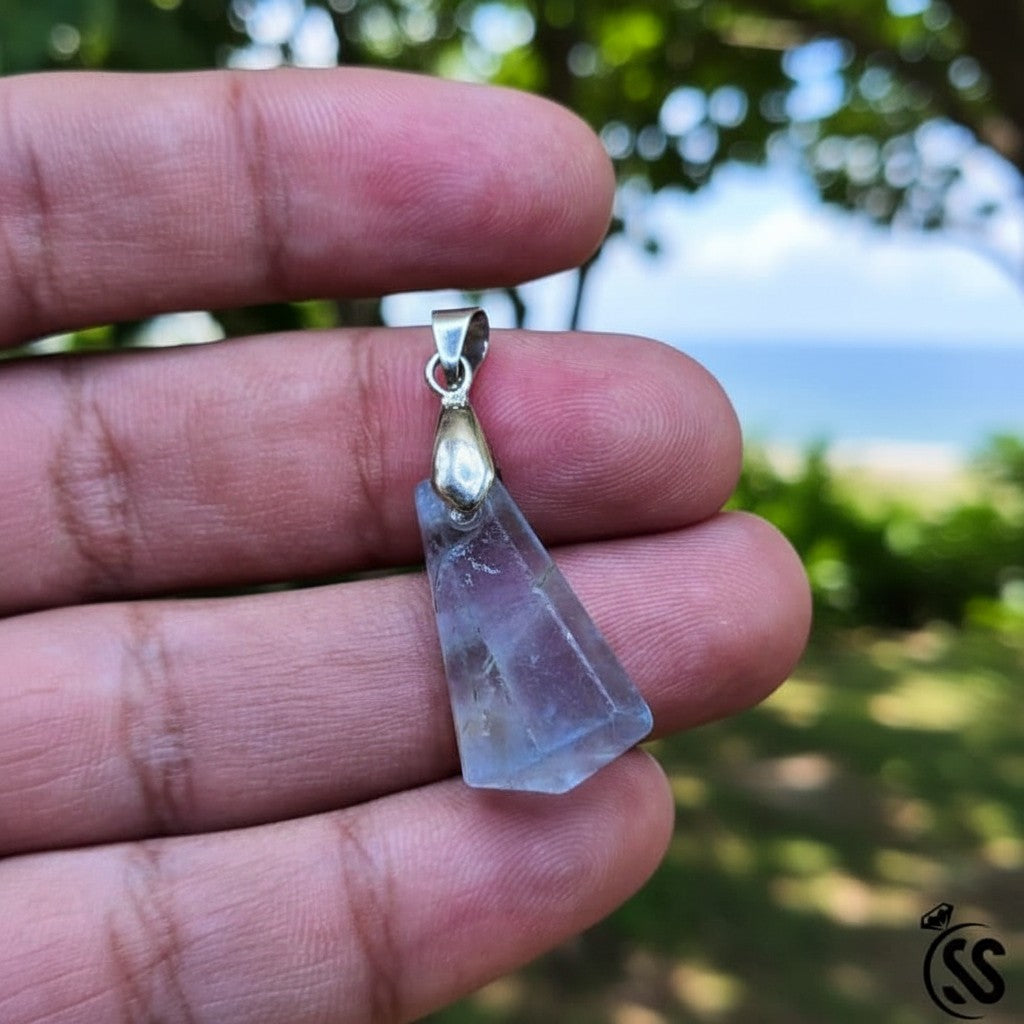 SilverStones.Pk triangular fluorite pendant with purple and green hues and a silver hook.