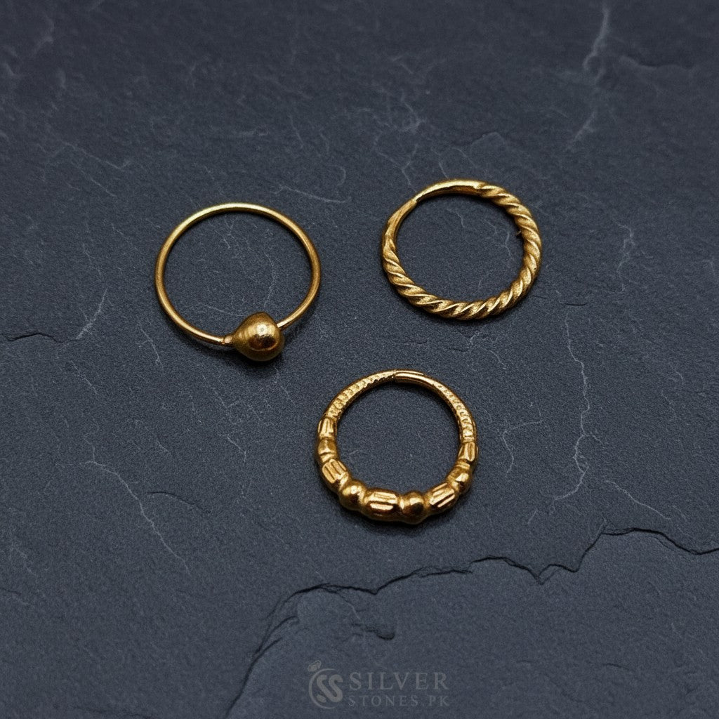 SilverStones.Pk pack of 3 gold-plated pure silver nose rings. Features a ball stud, twisted hoop, and beaded hoop design.