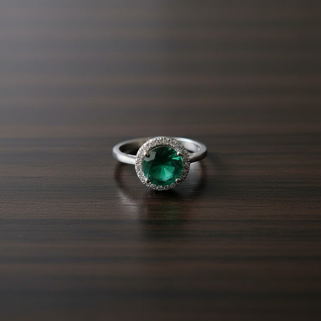 SilverStones.Pk designer ladies ring with a round green zircon stone surrounded by small clear zircon stones, set in silver-tone metal.