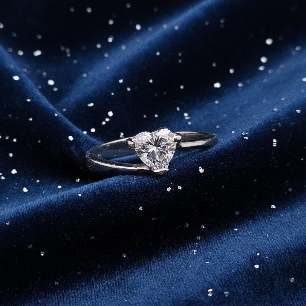 SilverStones.Pk ladies' 1 carat heart-shaped moissanite diamond ring in silver, set against a backdrop of green leaves.