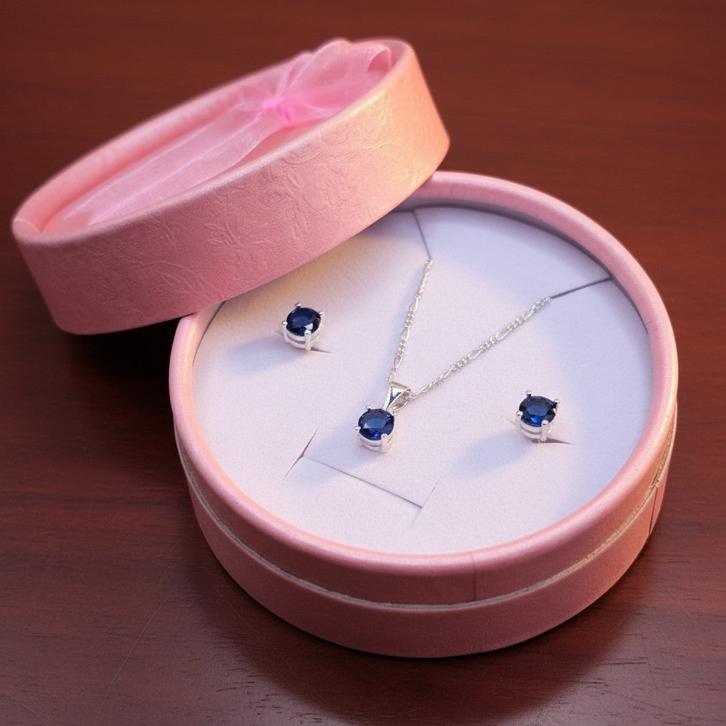 SilverStones.Pk Italian 925 sterling silver pendant and stud earrings set with deep blue oval zircon stones in a diamond-style setting, presented in a pink gift box.