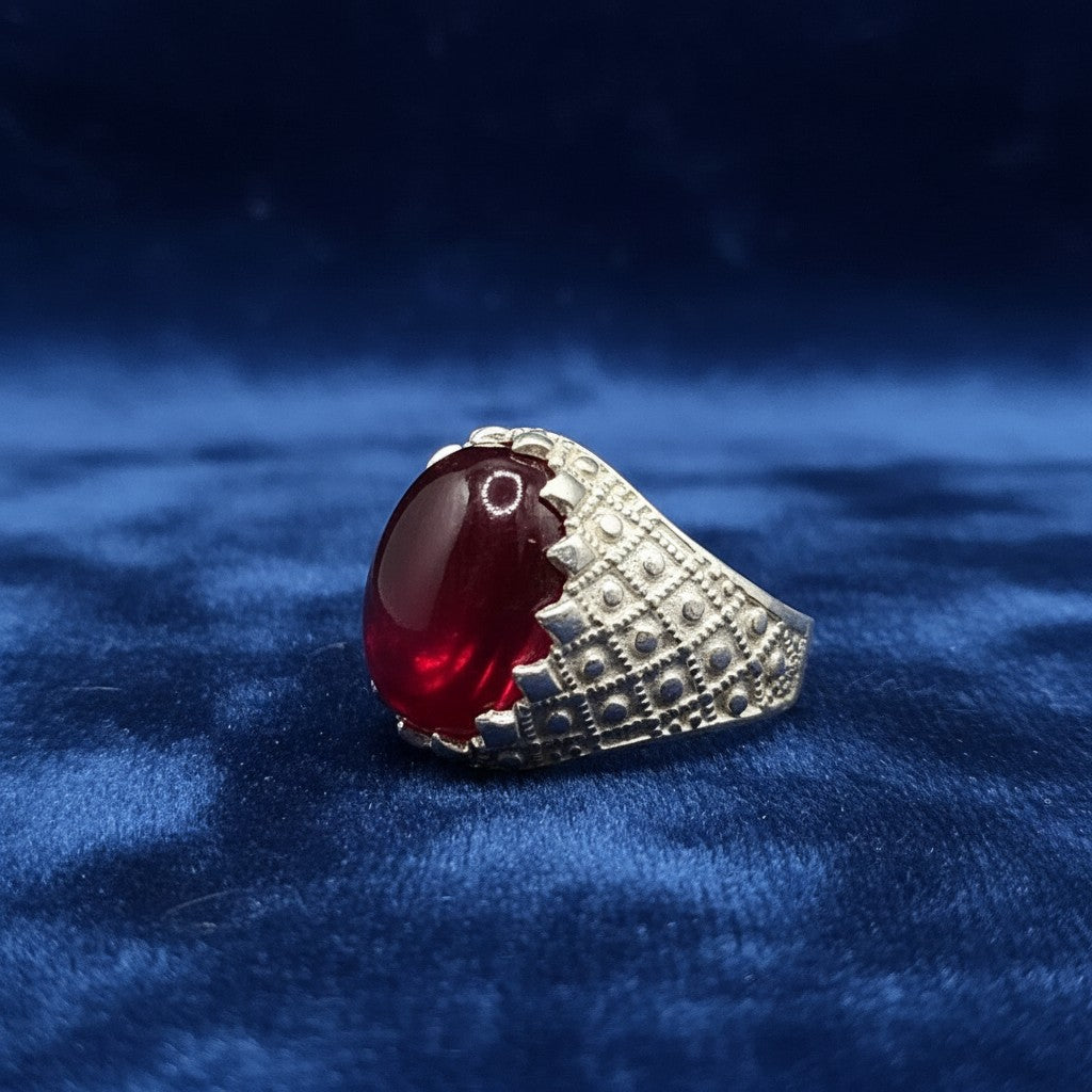 SilverStones.Pk men's silver ring with a large, oval, deep red Irani Anari Ruby gemstone. The band has a textured, patterned design.