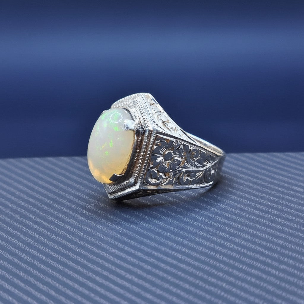 SilverStones.Pk men's handmade pure silver ring with a large oval opal stone and intricate floral engraving on the band.