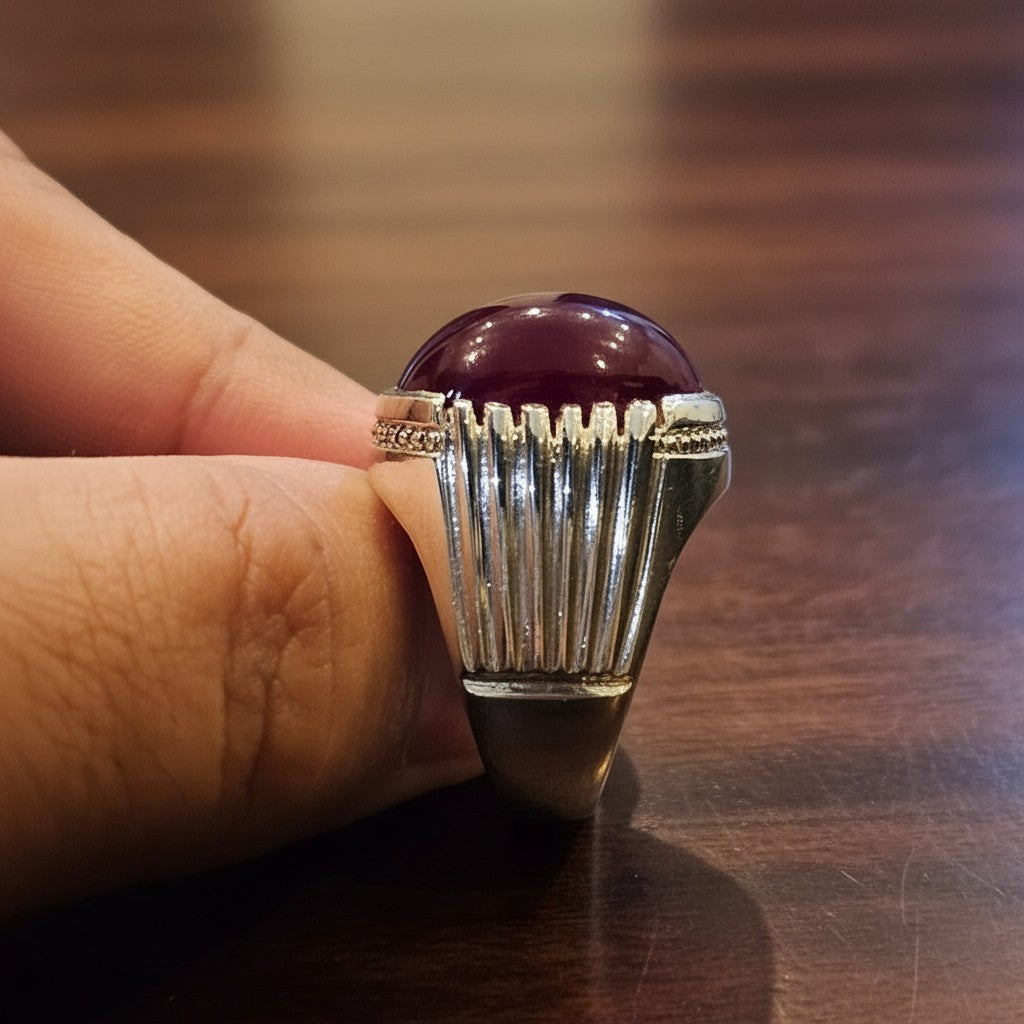 SilverStones.Pk men's silver ring with a large, cabochon-cut, deep red Irani Yaqoot (ruby) gemstone. Features a textured silver band with vertical ridges.