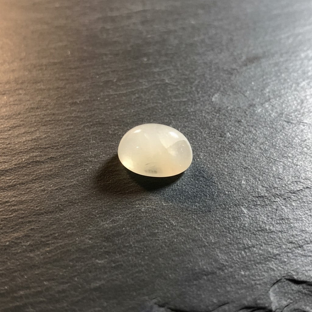 SilverStones.Pk oval cabochon gemstone, milky white to pale yellow, translucent, smooth polished surface for jewelry making.