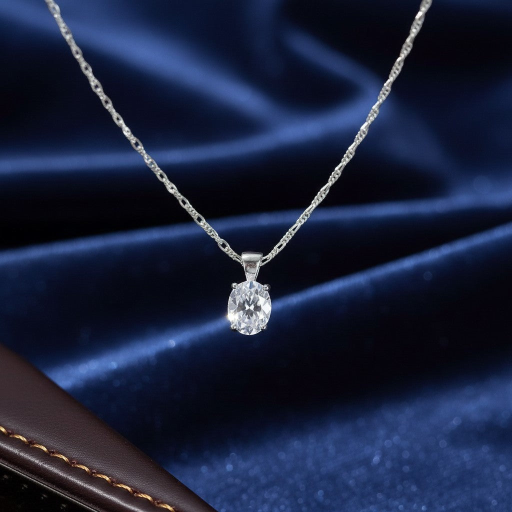 SilverStones.Pk oval-cut cubic zirconia pendant necklace on a delicate figaro chain. Clear gemstone.