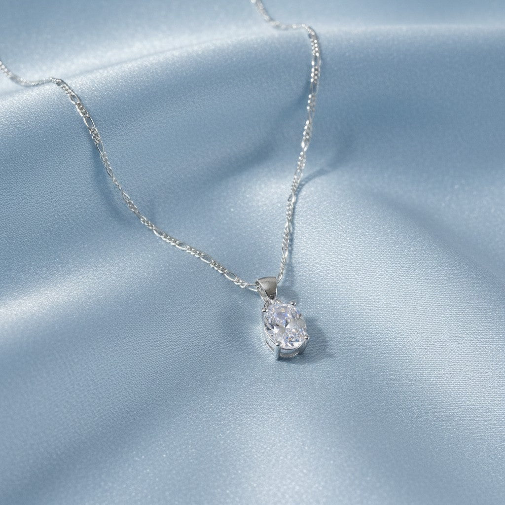 SilverStones.Pk sterling silver necklace with oval-cut cubic zirconia pendant on a figaro chain.