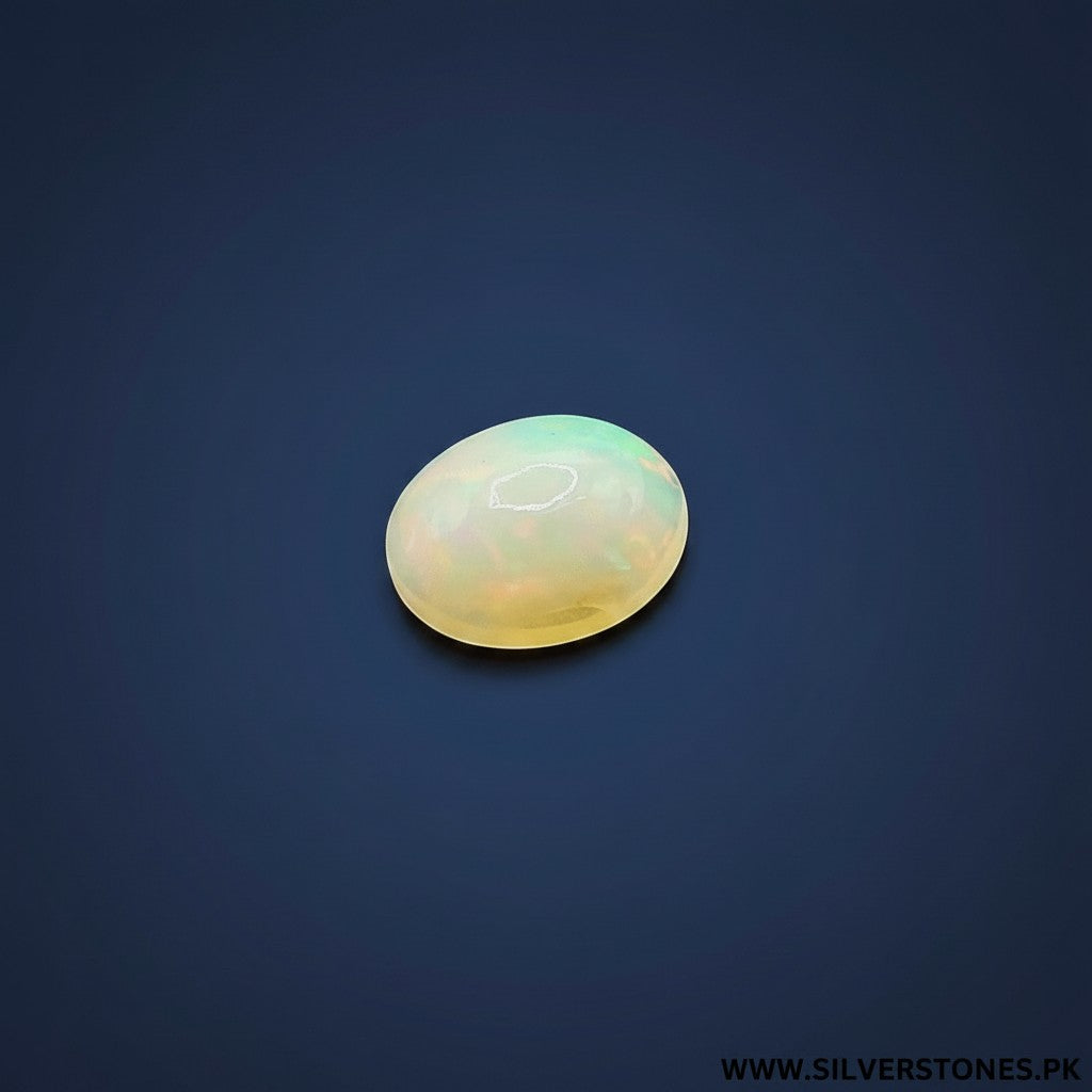 SilverStones.Pk oval white Ethiopian opal gemstone with a radiant play-of-color, showing hints of green and yellow.