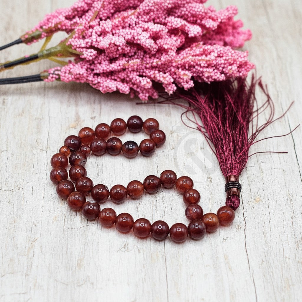 Silverstones.Pk real aqeeq stone tasbeeh with burgundy tassel. Smooth, polished, translucent red-brown beads.