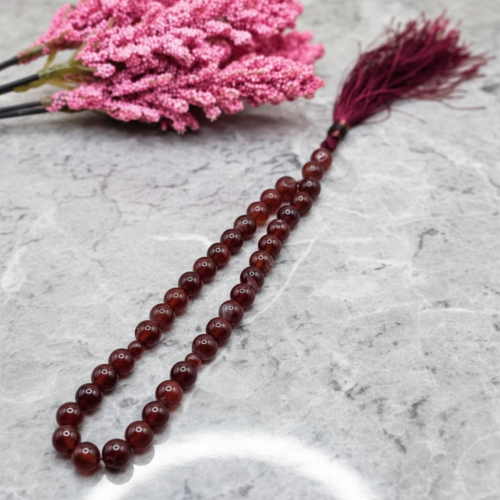 SilverStones.Pk real aqeeq stone tasbeeh with burgundy tassel. Smooth, polished beads in warm red and brown tones.