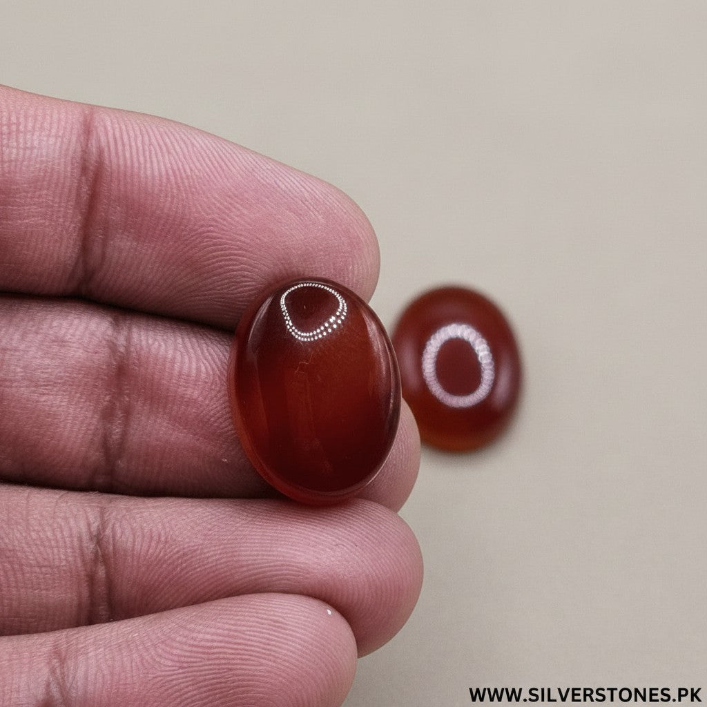 SilverStones.Pk real Yamni Aqeeq stones in deep red and orange oval cabochon cuts, showcasing natural banding and polished finish.