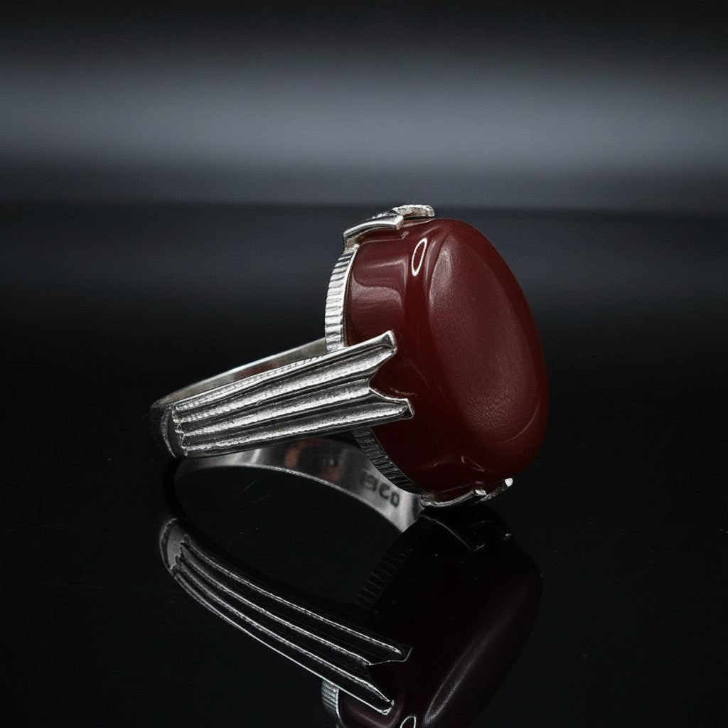 SilverStones.Pk handmade sterling silver ring featuring a large, oval, deep red aqeeq gemstone. The band has a textured, ribbed design.