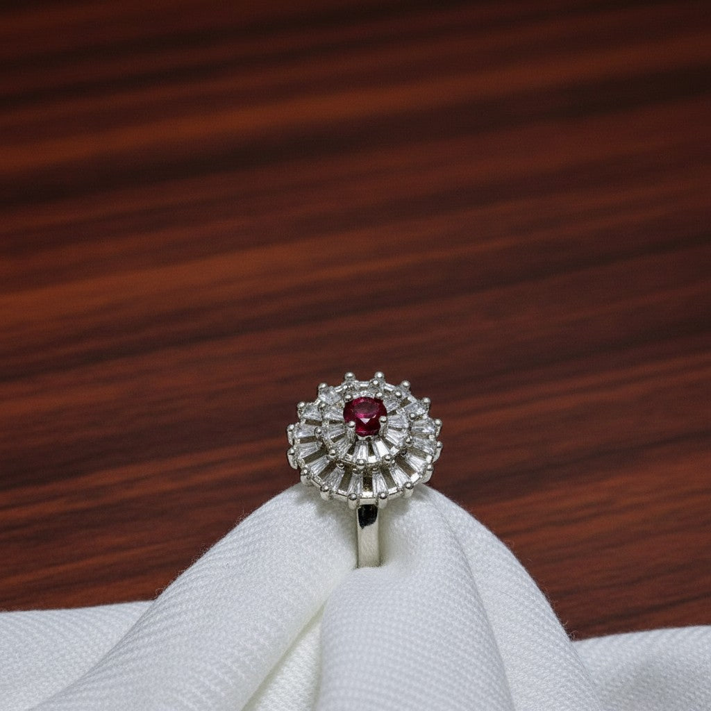 SilverStones.Pk imitation ladies ring with a central red zircon and surrounding clear baguette and round zircon stones in a floral design.