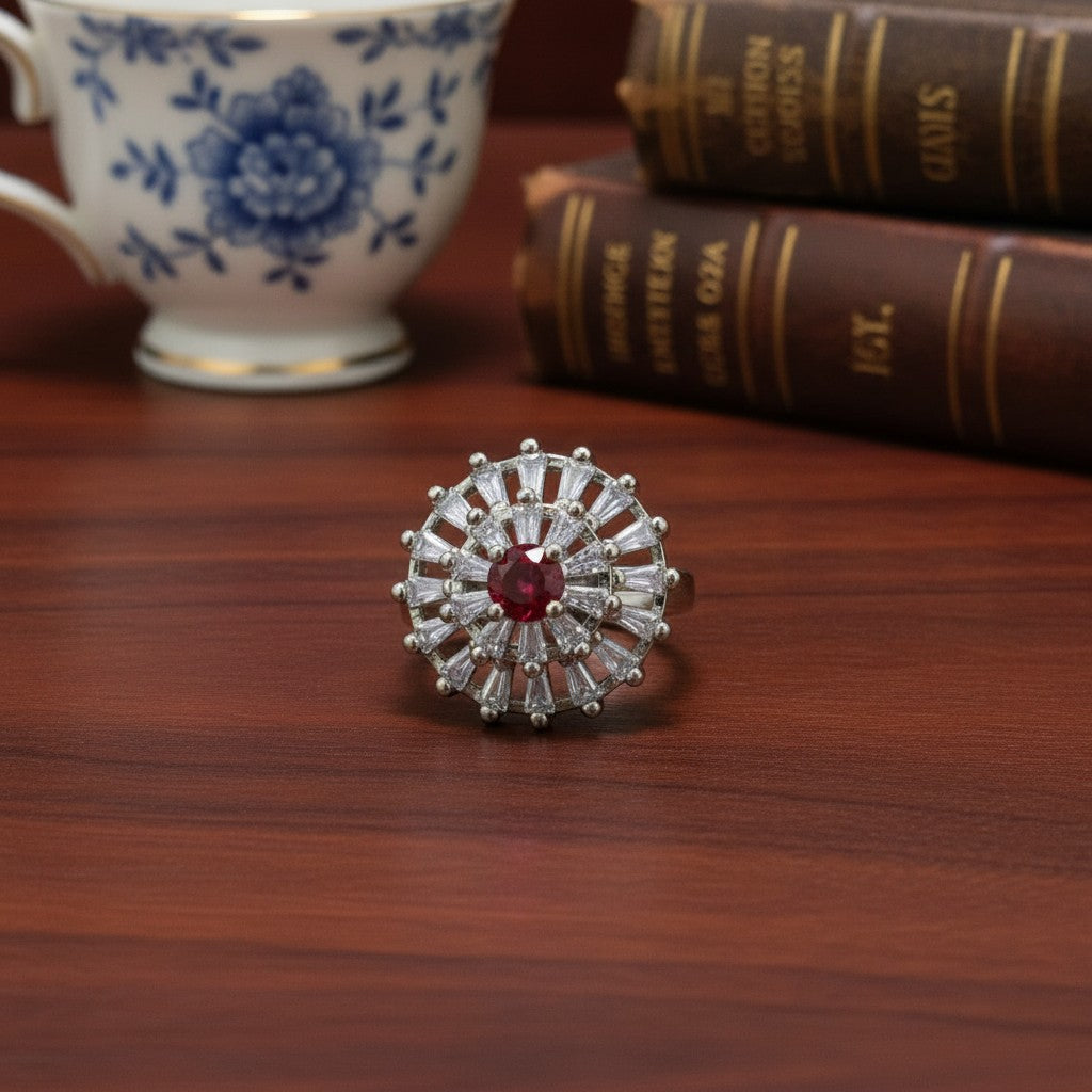 SilverStones.Pk imitation ring with red zircon center and baguette-cut clear stones in a sunburst design.