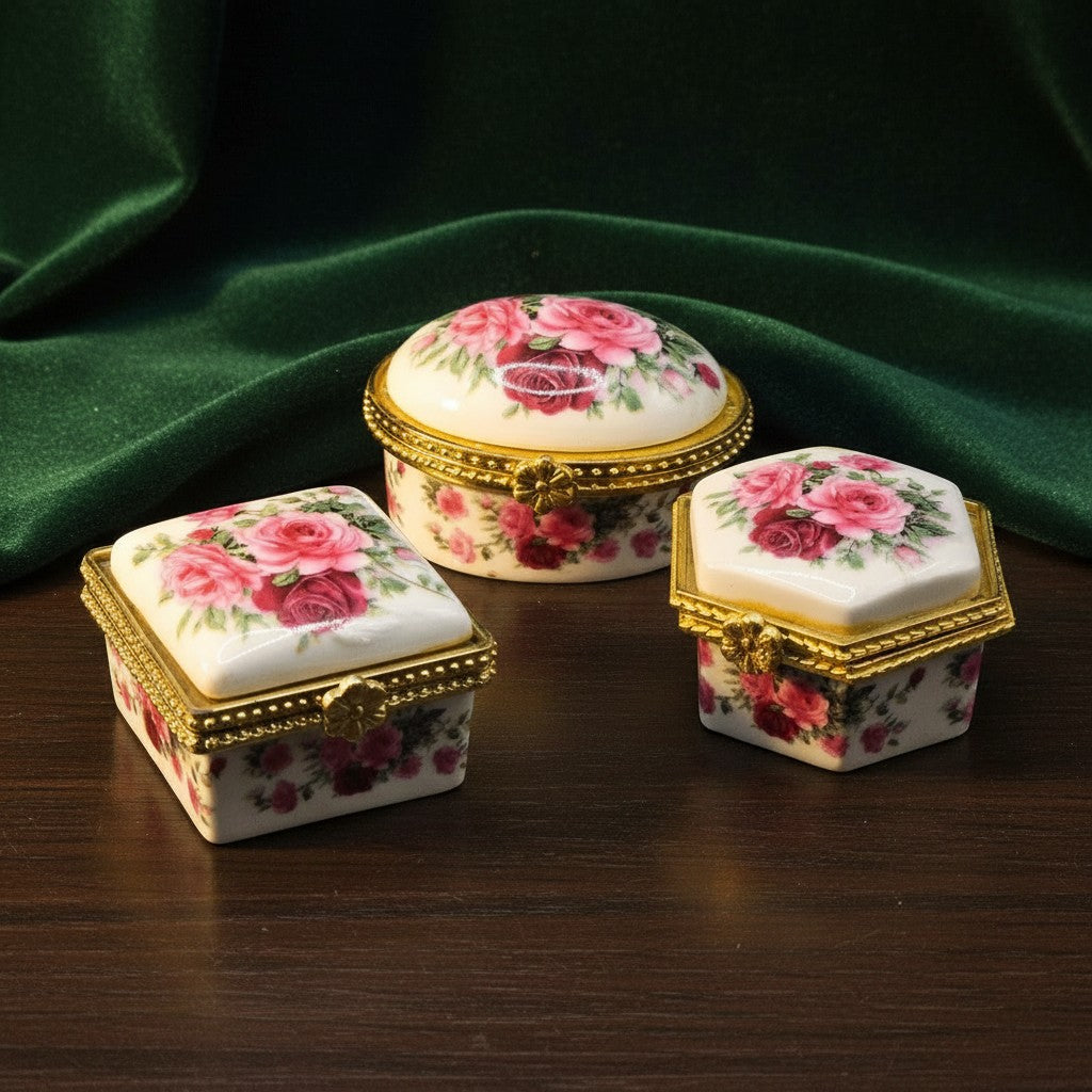 SilverStones.Pk ornate porcelain jewelry boxes with pink roses and gold trim. Three decorative boxes in oval, square, and hexagonal shapes.